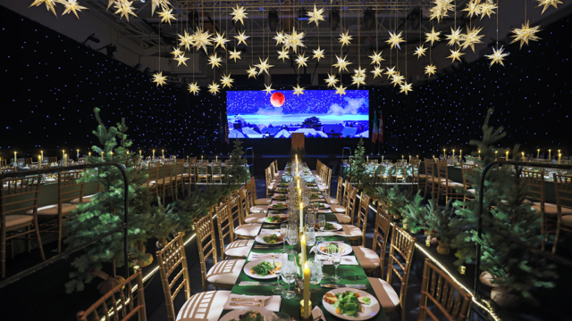 Long tables with place settings and stars hanging down from the ceiling.