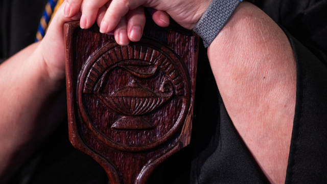 Close up image of the college mace showing carving in the wooden item.